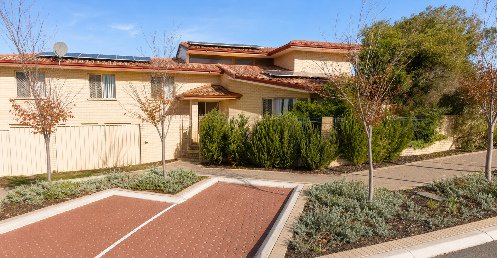 Wattle Tree Lodge exterior with a flowering wattle tree in the front garden